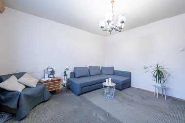 Rahat bir kanepe, zarif bir dekor ve şık mobilyalarla dolu parlak ve temiz bir oturma odası. Modern ve rahat bir ev ortamının mükemmel bir temsili..