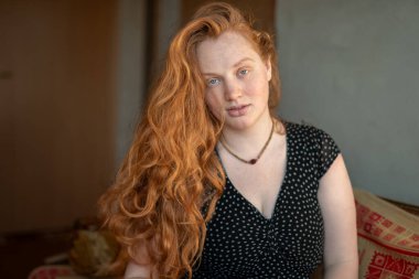 Kafkasyalı beyaz bir kadının sakin ve düşünceli bir portresi. Çekici kızıl saçlı, kızıl saçlı, evde oturan ve rahat oturan...,