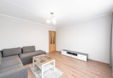 Gri bölmeli kanepesi, ahşap döşemesi ve zarif ışıklandırması olan, çağdaş minimalist bir tasarımın somutlaştırıldığı açık ve ferah bir oturma odası. Hafif tonlarda sadelik sakin bir karşılama ortamı sunar..