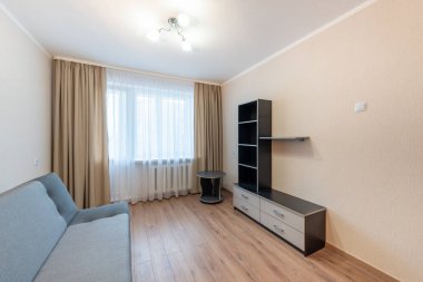 Gri bölmeli kanepesi, ahşap döşemesi ve zarif ışıklandırması olan, çağdaş minimalist bir tasarımın somutlaştırıldığı açık ve ferah bir oturma odası. Hafif tonlarda sadelik sakin bir karşılama ortamı sunar..