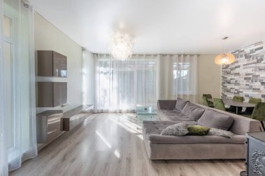 Geniş oturma odası geniş bir kanepe, doğal ışık ve rahat ahşap sobası olan çağdaş bir tasarım içeriyor..