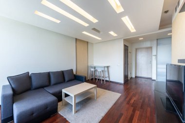 Modern Ev Minimalist Oturma Odası. Minimalist dekor, rahat bir kanepe ve sıcak ışıklandırmanın yer aldığı gösterişli ve modern bir oturma odası. Ev tasarımı için ideal