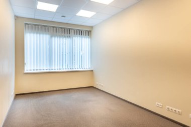 Geniş pencereleri ve temiz tasarımı olan parlak ve boş ofis içi, doğal ışıkla aydınlatılmış profesyonel bir çalışma alanı sunuyor. Geniş Pencereli İyi Aydınlatılmış Boş Oda İçi Temiz Tasarım