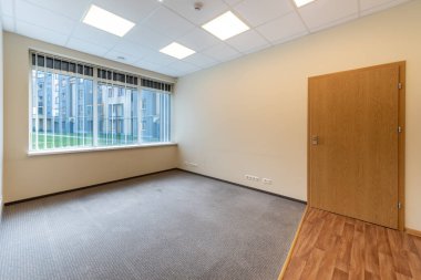 Geniş pencereleri ve temiz tasarımı olan parlak ve boş ofis içi, doğal ışıkla aydınlatılmış profesyonel bir çalışma alanı sunuyor. Geniş Pencereli İyi Aydınlatılmış Boş Oda İçi Temiz Tasarım
