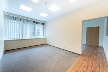 Geniş pencereleri ve temiz tasarımı olan parlak ve boş ofis içi, doğal ışıkla aydınlatılmış profesyonel bir çalışma alanı sunuyor. Geniş Pencereli İyi Aydınlatılmış Boş Oda İçi Temiz Tasarım