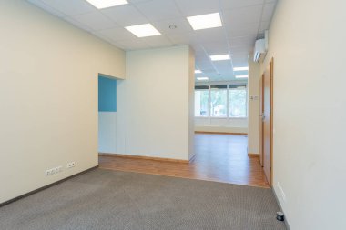 Geniş pencereleri ve temiz tasarımı olan parlak ve boş ofis içi, doğal ışıkla aydınlatılmış profesyonel bir çalışma alanı sunuyor. Geniş Pencereli İyi Aydınlatılmış Boş Oda İçi Temiz Tasarım