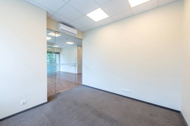 Geniş pencereleri ve temiz tasarımı olan parlak ve boş ofis içi, doğal ışıkla aydınlatılmış profesyonel bir çalışma alanı sunuyor. Geniş Pencereli İyi Aydınlatılmış Boş Oda İçi Temiz Tasarım