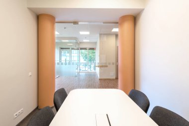Minimalist mobilyalarla dolu cam duvarlı bir toplantı odası olan parlak ve modern bir ofis. Camdan Bölümler ve Minimalist Mobilya Tasarımı ile Modern Ofis İçi.