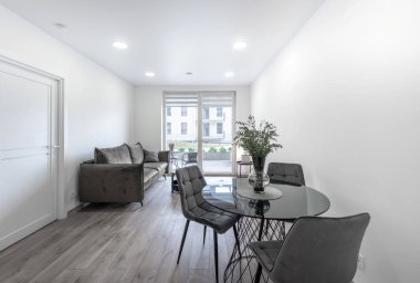 Açık Alan, Kanepe ve Yemek Masası ile Modern Ev Oturma Odası İçi. Masada çiçekler var. Arka plandaki pencereler. Ahşap zemin. Geniş Açı