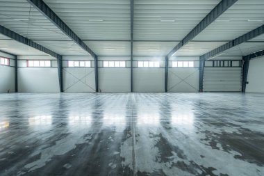 Boş Endüstri Deposu. Geniş, açık, parlayan beton zemin, çelik kirişler ve parlak ışıklandırma içeren bir sanayi deposu. Bu alan depolama, lojistik ve imalat için ideal..