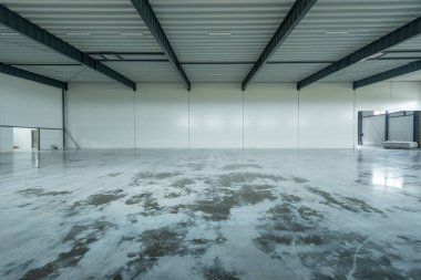 Boş Endüstri Deposu. Geniş, açık, parlayan beton zemin, çelik kirişler ve parlak ışıklandırma içeren bir sanayi deposu. Bu alan depolama, lojistik ve imalat için ideal..