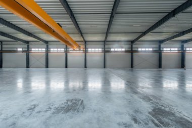 Parlak doğal ışıklandırmanın yer aldığı geniş, temiz ve modern bir sanayi deposunun iç manzarası. Modern tasarımı olan büyük bir sanayi deposu. Turna