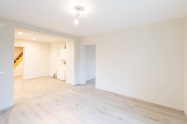 Ahşap kaplama döşeme, tarafsız duvarlar ve çağdaş bir titreşim ile iyi aydınlatılmış geniş bir oda. Ahşap döşemeleri olan parlak, modern boş oda. Yeni İnşaat İç mimarisi