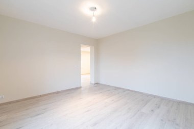 Ahşap kaplama döşeme, tarafsız duvarlar ve çağdaş bir titreşim ile iyi aydınlatılmış geniş bir oda. Ahşap döşemeleri olan parlak, modern boş oda. Yeni İnşaat İç mimarisi