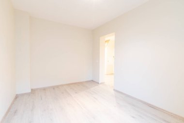 Ahşap kaplama döşeme, tarafsız duvarlar ve çağdaş bir titreşim ile iyi aydınlatılmış geniş bir oda. Ahşap döşemeleri olan parlak, modern boş oda. Yeni İnşaat İç mimarisi