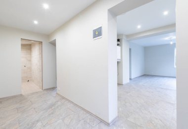 Ahşap kaplama döşeme, tarafsız duvarlar ve çağdaş bir titreşim ile iyi aydınlatılmış geniş bir oda. Ahşap döşemeleri olan parlak, modern boş oda. Yeni İnşaat İç mimarisi