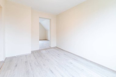 Ahşap döşemeleri ve geniş pencereleri olan boş bir odanın yeni, parlak ve modern iç mimarisi. Ev İçi