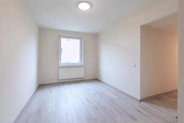 Ahşap döşemeleri ve geniş pencereleri olan boş bir odanın yeni, parlak ve modern iç mimarisi. Ev İçi