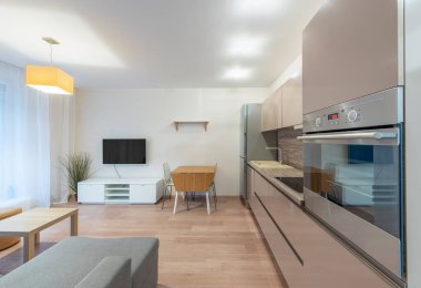 Geniş ve zarif bir şekilde tasarlanmış, şehir yaşam tarzı ve konforu için ideal çağdaş bir mutfak ve şık bir yaşam alanı içeriyor. Modern Ev Açık Planlı Ev Apartmanı Mutfağı