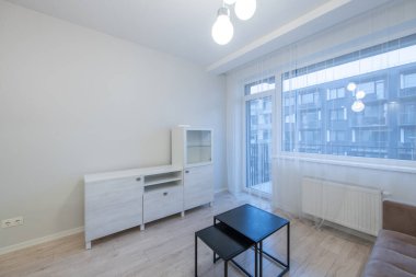 Çağdaş mobilyaların yer aldığı parlak ve havadar bir daire geniş pencerelerden geçen doğal ışık ve temiz, minimalist bir estetik. Minimalist Ev İçki Odası. Daire İçi