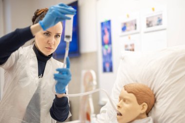 Sağlık çalışanı, profesyonel bir çevrede hasta bakımı teknikleri uygular, eğitim, hassasiyet ve sağlık eğitimini vurgular. Hemşire ile Tıbbi Simülasyon Eğitimi