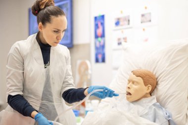 Sağlık çalışanı, profesyonel bir çevrede hasta bakımı teknikleri uygular, eğitim, hassasiyet ve sağlık eğitimini vurgular. Hemşire ile Tıbbi Simülasyon Eğitimi