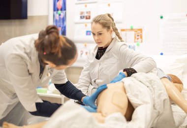 Odaklanmış sağlık öğrencileri, tıbbi eğitim oturumunda, gerçek boyutta bir model üzerinde klinik muayene teknikleri uygulayarak, elle öğrenme faaliyetlerinde bulunuyorlar. Enema Prosedür Eğitimi