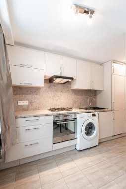 Dolap, lavabo, soba, fırın ve çamaşır makinesinin yer aldığı parlak ve iyi organize edilmiş bir mutfak. İç tasarım ve ev aletleri için ideal. Modern Ev Mutfağı İçi