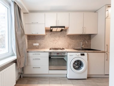 Dolap, lavabo, soba, fırın ve çamaşır makinesinin yer aldığı parlak ve iyi organize edilmiş bir mutfak. İç tasarım ve ev aletleri için ideal. Modern Ev Mutfağı İçi