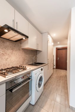 Dolap, lavabo, soba, fırın ve çamaşır makinesinin yer aldığı parlak ve iyi organize edilmiş bir mutfak. İç tasarım ve ev aletleri için ideal. Modern Ev Mutfağı İçi