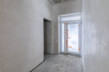 Odanın inşaatı devam ediyor. Duvarları alçılı, zemini beton. Giriş Salonu. Geniş Görünüm