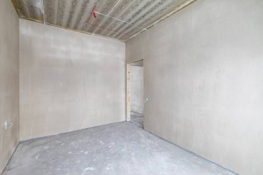 Odanın inşaatı devam ediyor. Duvarları alçılı, zemini beton. Oturma Odası Bölgesi. Geniş