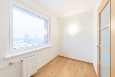 Geniş bir penceresi, parlak ahşap döşemesi ve sıcak bir ortam için sıcak ışıklandırması olan çağdaş tasarımı olan parlak bir iç mekan. Dışarıdaki manzara bir şehir kış manzarası sergiliyor..