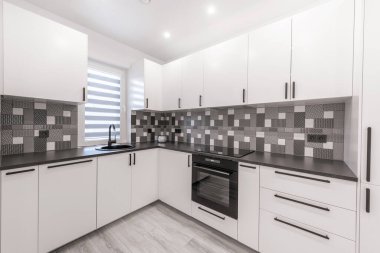 İskandinav Tarzı Konforlu Modern Açık Parlak Mutfak İç mimarisi. Arka planda musluk, buzdolabı, fırın, dolap ve mobilya. LED Işık, Siyah ve Beyaz Tarz. Geniş Açı