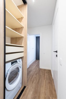 Ev Girişi, Koridor İçi. Ope Dolap Kapısı, İçerisi Çamaşır, Kahverengi Döşeme. Minimalizm. LED Işık. Ayna. Yatak odasına giden koridor. Geniş Açı