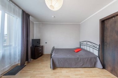 Modern Ev Oturma Odası ve Pencereler, Balkon. Lüks modern apartman dairesi. Açık Alan, Şık Yatak, İskandinav Tasarımı. Ahşap döşeme, Eski Retro Kapı. Geniş Açı