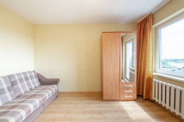 Minimalizm Ev Yatak Odası İçi. Dolap, Hardwood döşemesi. Koltuk, kanepe. Arka planda ısıtıcı ve pencere var. Ev