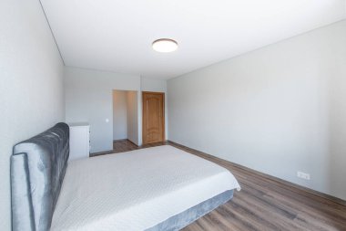 Ev Yatak Odası İçi. Büyük boy çift kişilik yatak, kahverengi tahta çıkış kapısı. Beyaz Duvar ve Tavan. LED Liaght. Dark Hardwood Zemini. Beyaz Çekmeceler. Geniş Açı