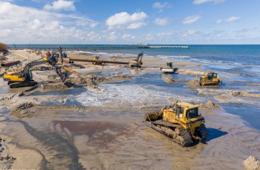 Plaj restorasyonu ve buldozerler. Denizin götürdüğü sahilin yeniden inşası için kazıcıyla birlikte borudan çamur akıyor. Plaj besinleri için çalışmalar devam ediyor. Drone Hava Çekimi