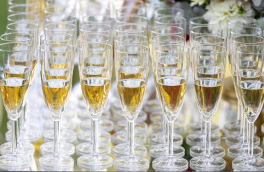 Masada köpüklü şarapla dolu zarif şampanya kadehleri. Düğünler, partiler veya etkinlikler için ideal bir kutlama ortamı.