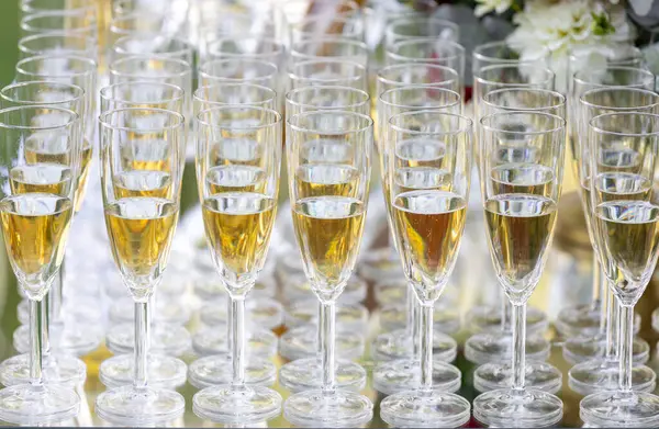 Masada köpüklü şarapla dolu zarif şampanya kadehleri. Düğünler, partiler veya etkinlikler için ideal bir kutlama ortamı.