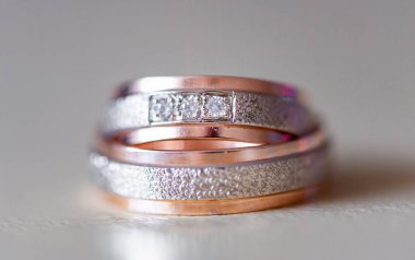 Karmaşık bir şekilde tasarlanmış elmas yüzükler gül altın ve gümüşle süslenmiş lüks ve bağlılık göstergesi. Karmaşık detaylar aşkı, güzelliği ve zamansızlığı vurgular.