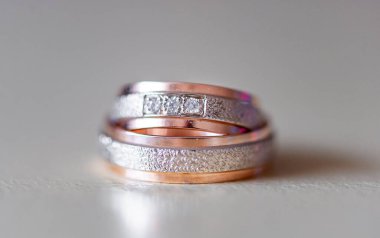 Gümüşten ve gümüşten oluşan alyanslardan oluşan bir üçlü. Yumuşak, aydınlık bir zemin ve narin bir yansıtıcı efektle sergilenen altın elementler..