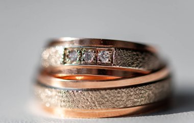 Karmaşık bir şekilde tasarlanmış elmas yüzükler gül altın ve gümüşle süslenmiş lüks ve bağlılık göstergesi. Karmaşık detaylar aşkı, güzelliği ve zamansızlığı vurgular.