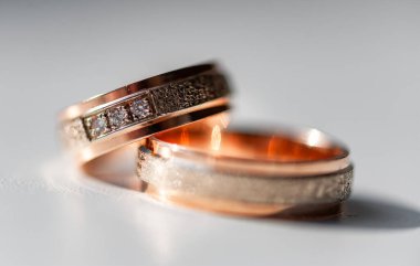 Karmaşık bir şekilde tasarlanmış elmas yüzükler gül altın ve gümüşle süslenmiş lüks ve bağlılık göstergesi. Karmaşık detaylar aşkı, güzelliği ve zamansızlığı vurgular.