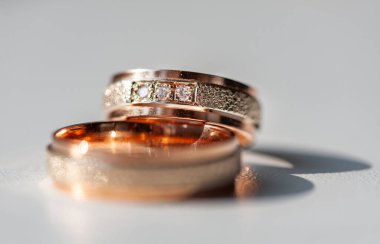 Karmaşık bir şekilde tasarlanmış elmas yüzükler gül altın ve gümüşle süslenmiş lüks ve bağlılık göstergesi. Karmaşık detaylar aşkı, güzelliği ve zamansızlığı vurgular.