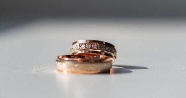 Karmaşık bir şekilde tasarlanmış elmas yüzükler gül altın ve gümüşle süslenmiş lüks ve bağlılık göstergesi. Karmaşık detaylar aşkı, güzelliği ve zamansızlığı vurgular.