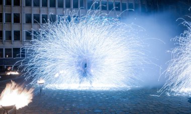 Göz kamaştırıcı bir ışık gösterisi, şehir avlusunu aydınlatıyor. Parlak mavi havai fişekler, büyüleyici bir sanat ve atmosfer gösterisiyle enerji ve hareket yayıyor..