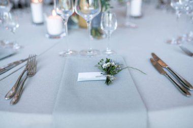 Sofistike çatal bıçak takımları, cam takımları ve çiçek desenli, zarif ve sofistike bir ortam yayan, lüks etkinlikler ve törenler için ideal bir düğün sofrası..