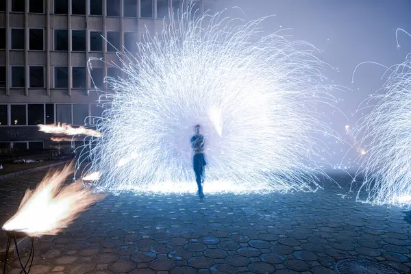 Göz kamaştırıcı bir ışık gösterisi, şehir avlusunu aydınlatıyor. Parlak mavi havai fişekler, büyüleyici bir sanat ve atmosfer gösterisiyle enerji ve hareket yayıyor..